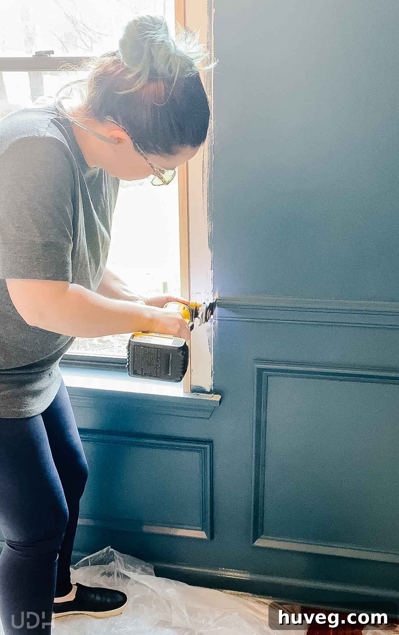 removing small pieces of chair rail from the window trim to make room for the new window insert using a multi-tool