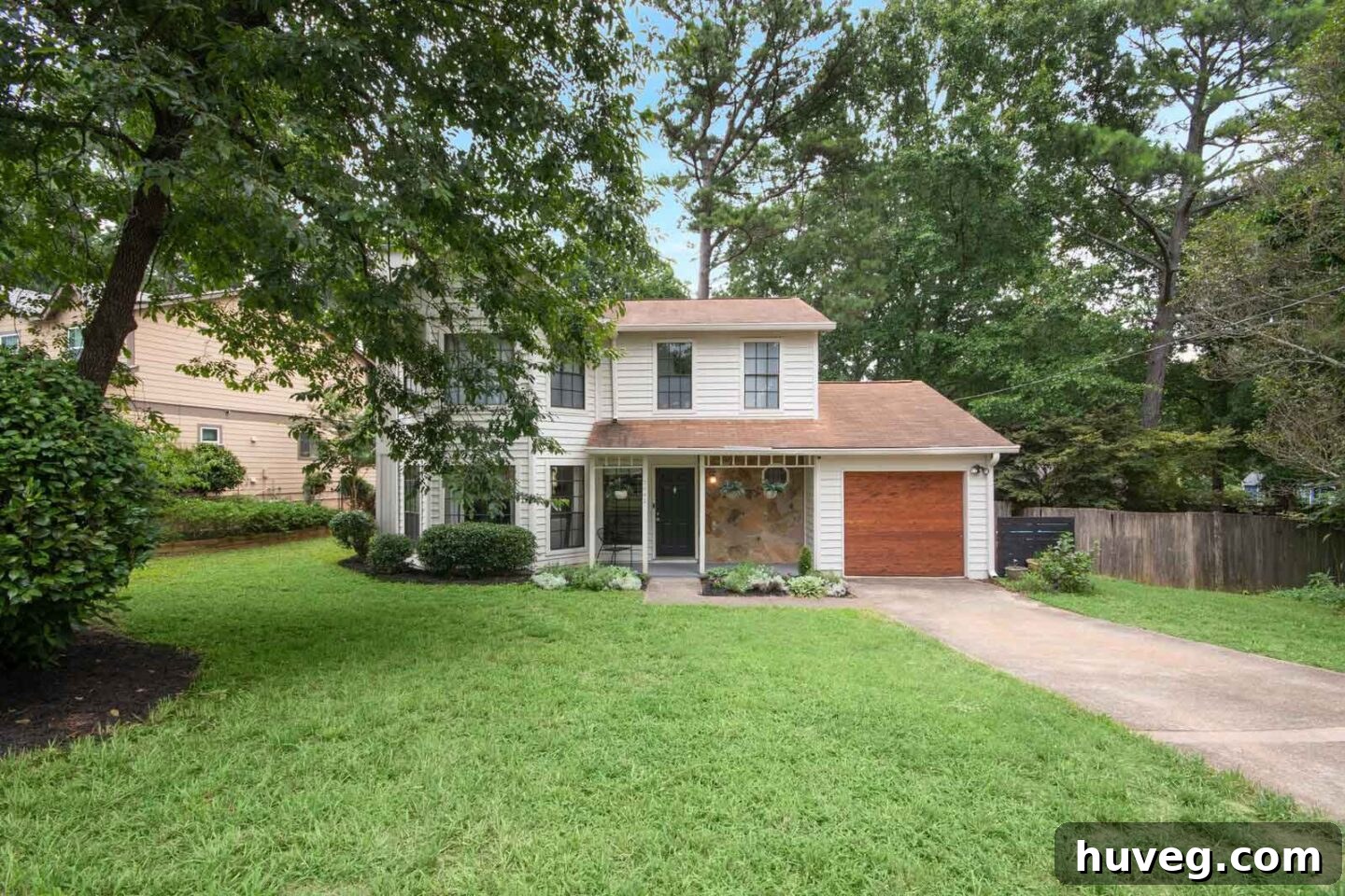 front yard white house with stained wood garage door