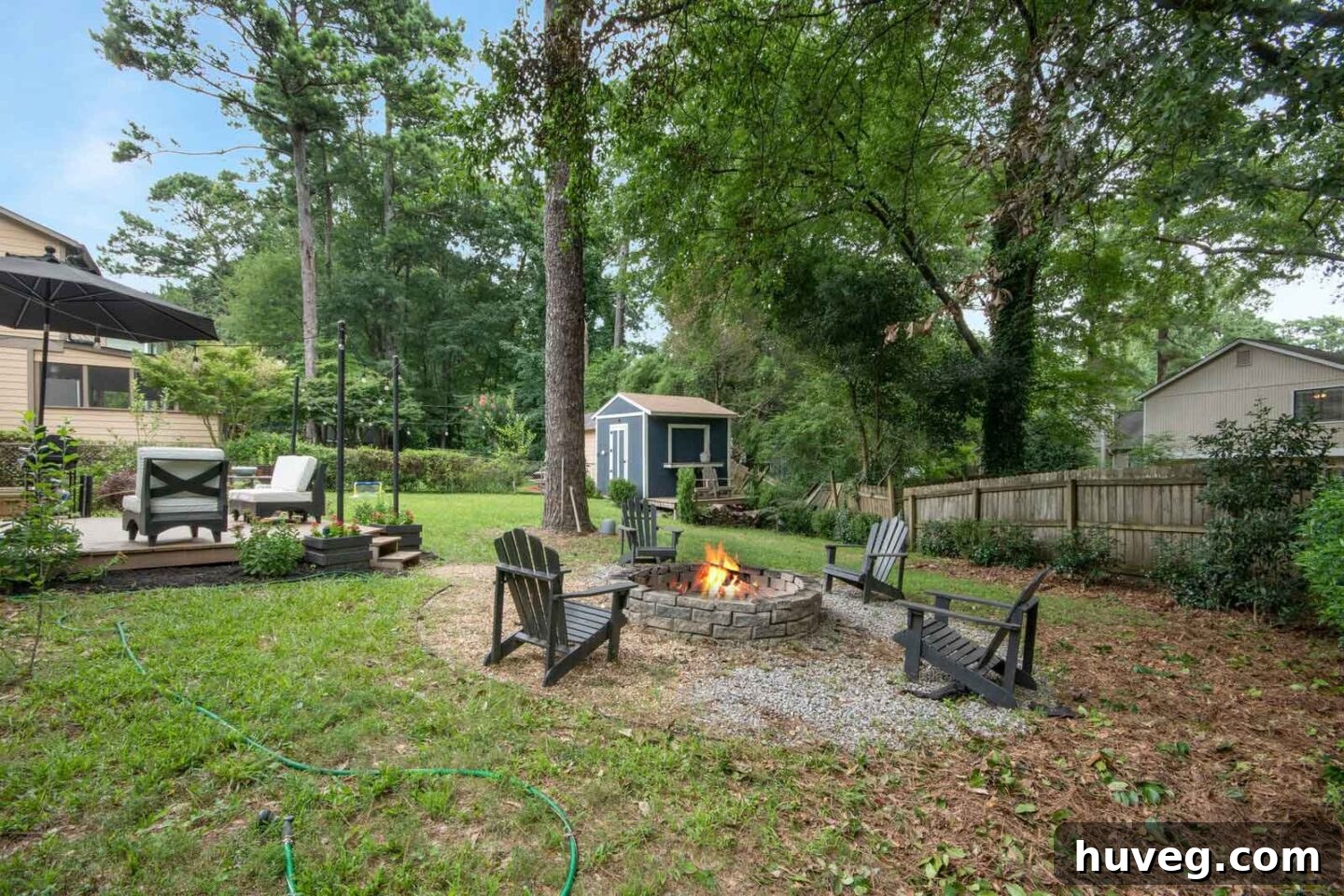 back yard fire pit view with navy blue shed in background