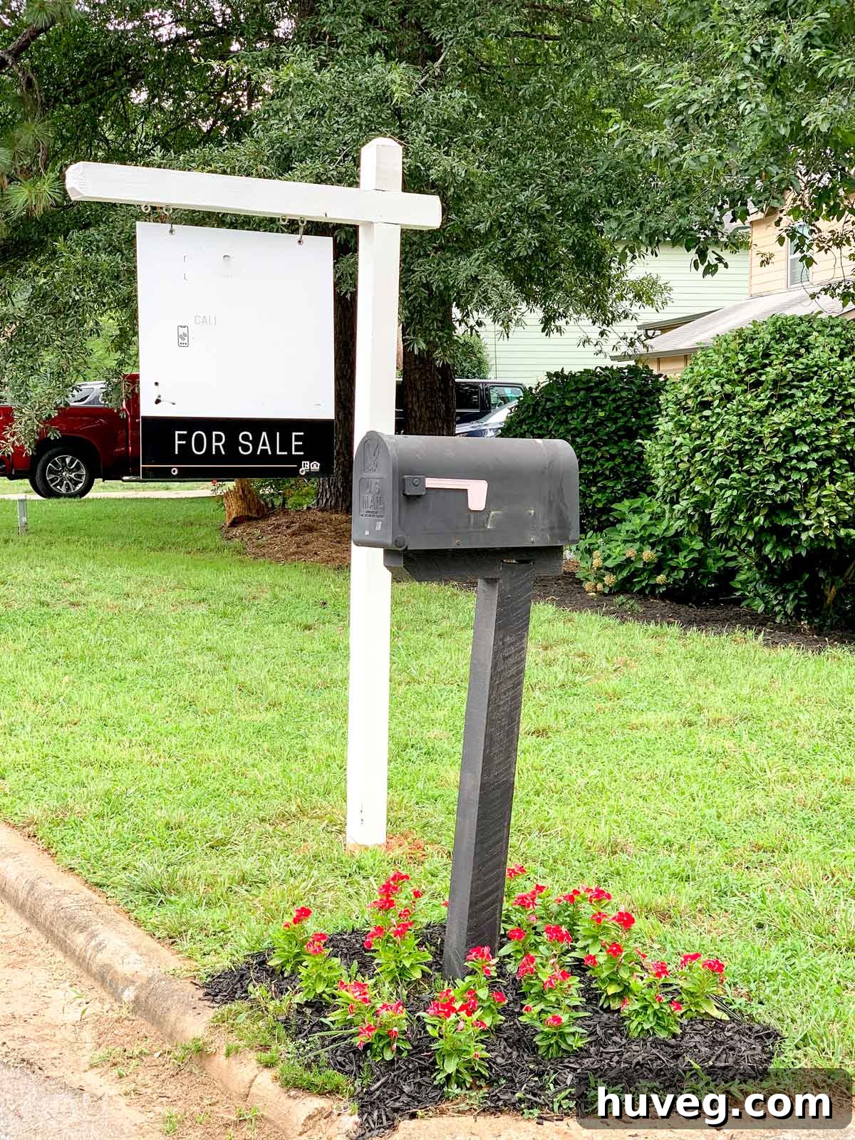 A vibrant 'For Sale' sign standing proudly in the front yard of our house, signifying a new chapter.