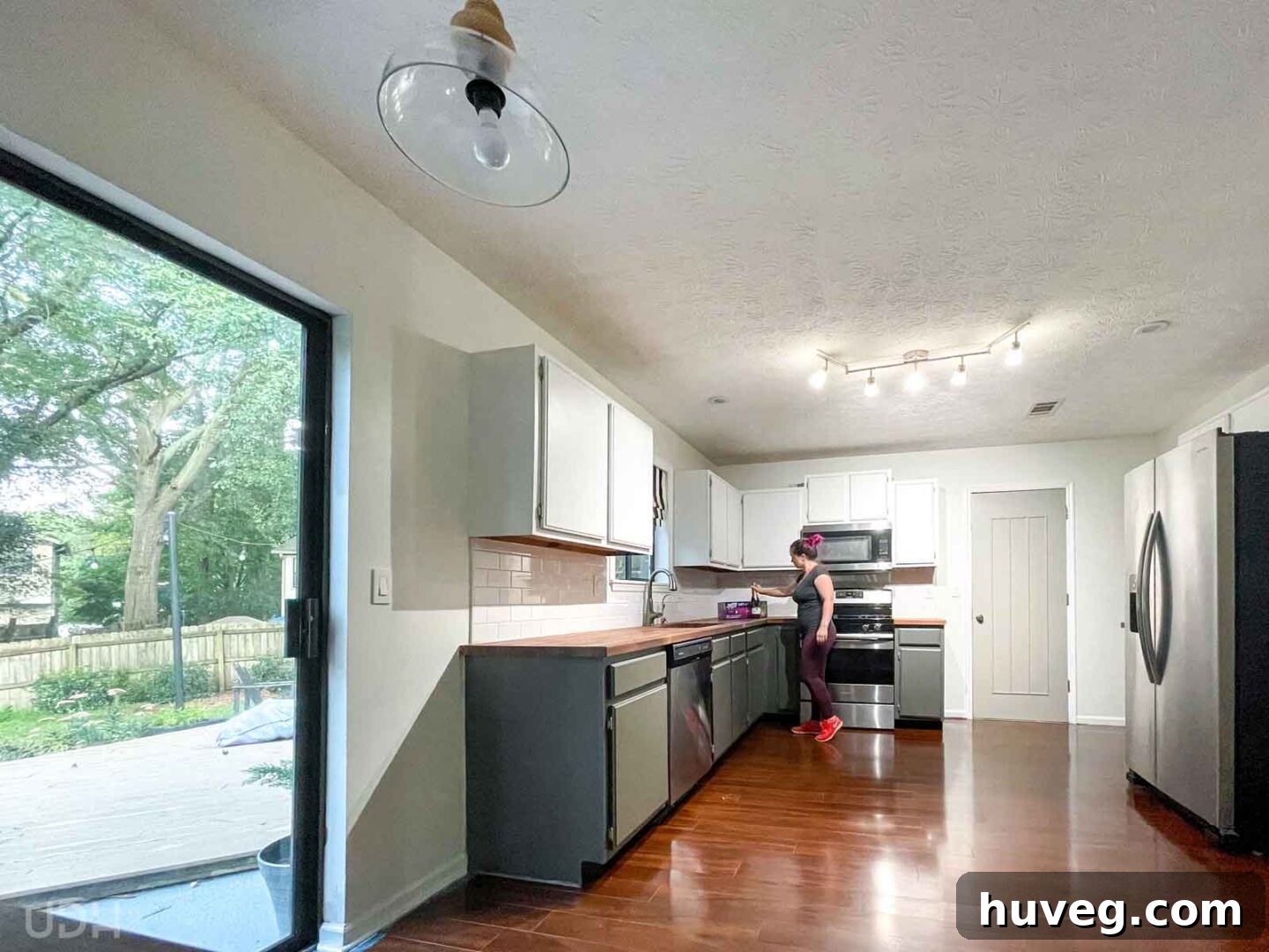 A thoughtful gesture: I'm seen placing a bottle of champagne and a new Swiffer Wet Jet on the kitchen counter, a welcome gift for the new homeowners.