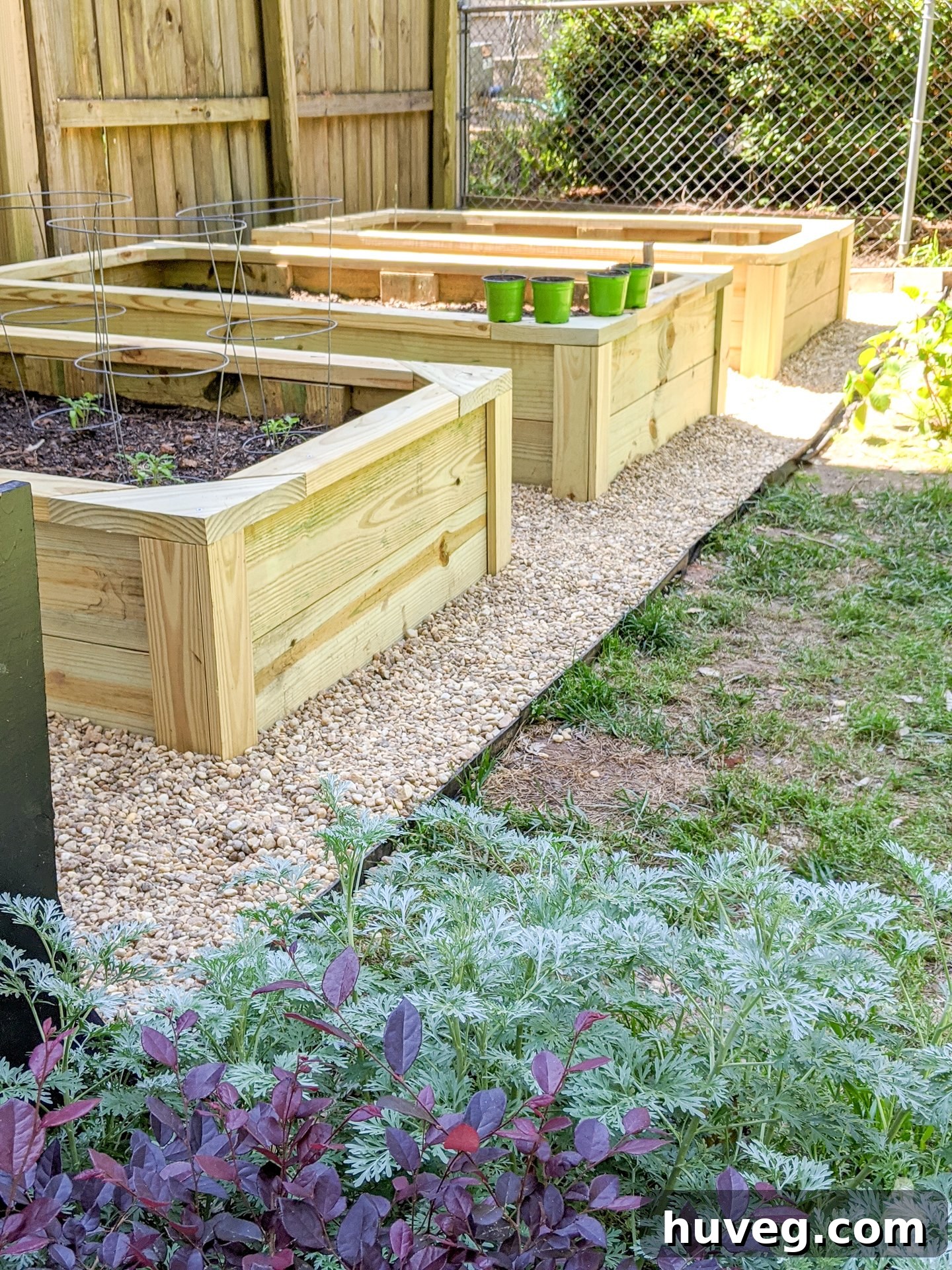 Sturdy and well-maintained garden beds situated in the corner of a backyard, ready for planting.
