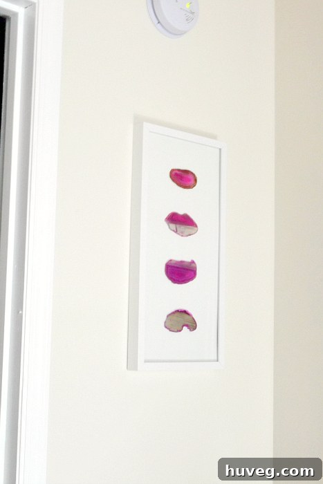 The process of arranging four pink agate slices within a chosen frame for a unique wall art piece.