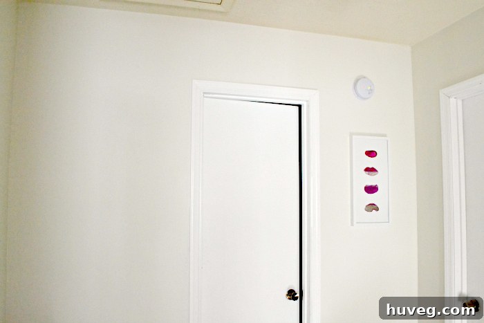 A wider perspective of the hallway, showcasing the pink agate slice art and the potential for future decor additions.