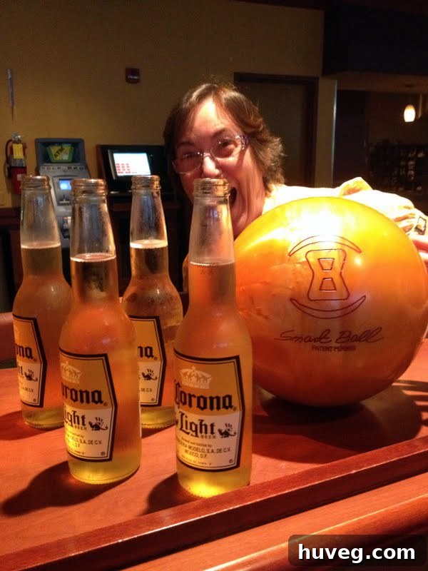 My mom, mid-throw at a bowling alley, concentrating intently on her ball, surrounded by the vibrant atmosphere.