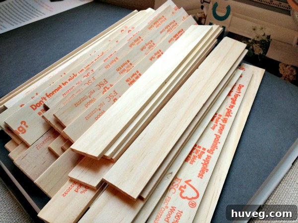 A large pile of wooden paint sticks, neatly stacked with their ends cut off, ready for a DIY project.