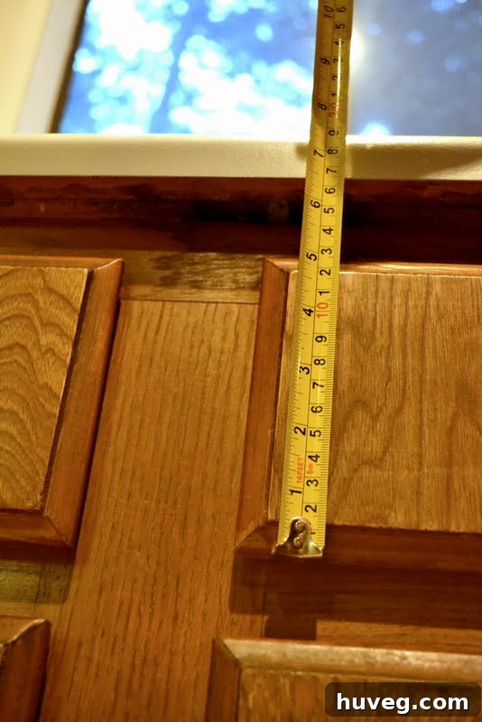 A tape measure stretching across a kitchen counter, symbolizing the start of precise kitchen renovation measurements.