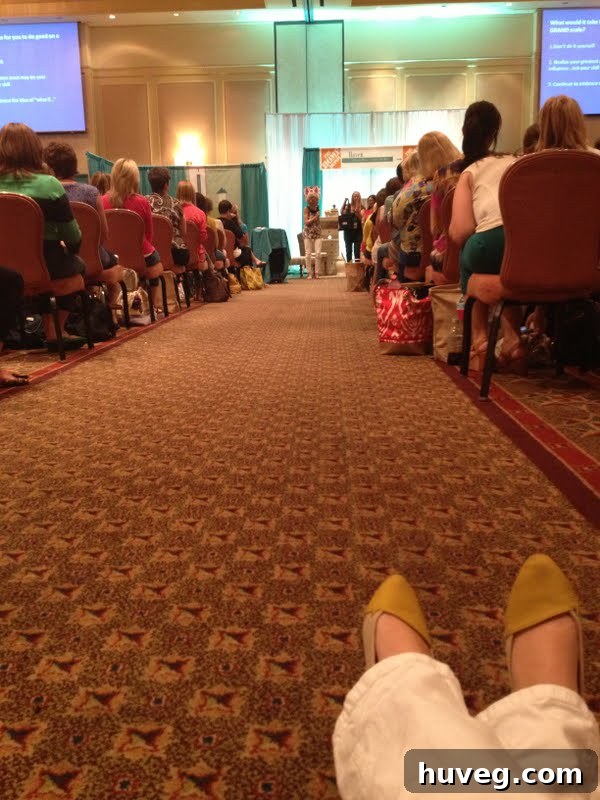 A blogger sitting on the floor, captivated by a speaker at the Haven Conference