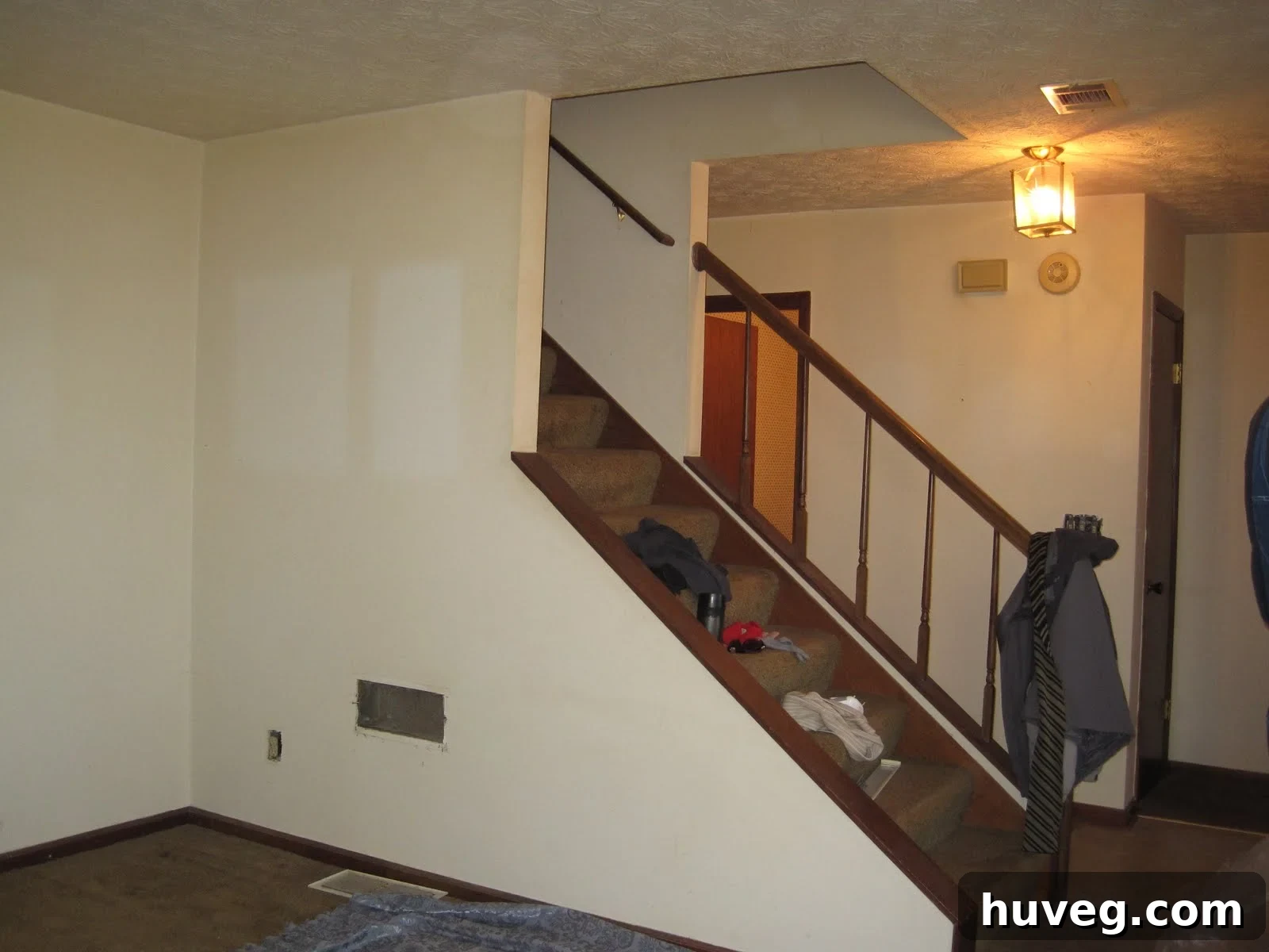 The original, unpainted state of a wall from three and a half years ago, showing an exposed vent and electrical outlet