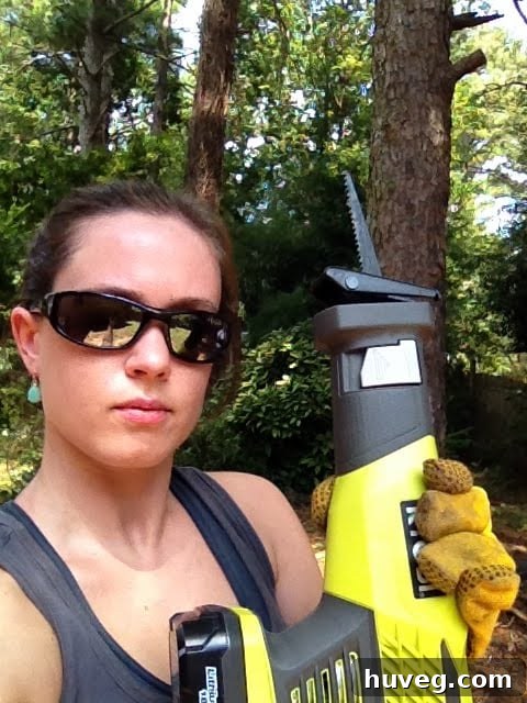 Determined gardener posing with a reciprocating saw after pruning
