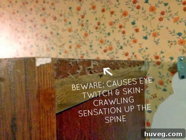 An extremely dirty, greasy, and grimy surface on an old kitchen cabinet revealed after removing its molding