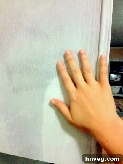 Performing a touch test on newly primed cabinets to confirm fast drying