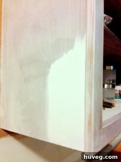 Testing Benjamin Moore's Decorator's White paint on a section of primed kitchen cabinet