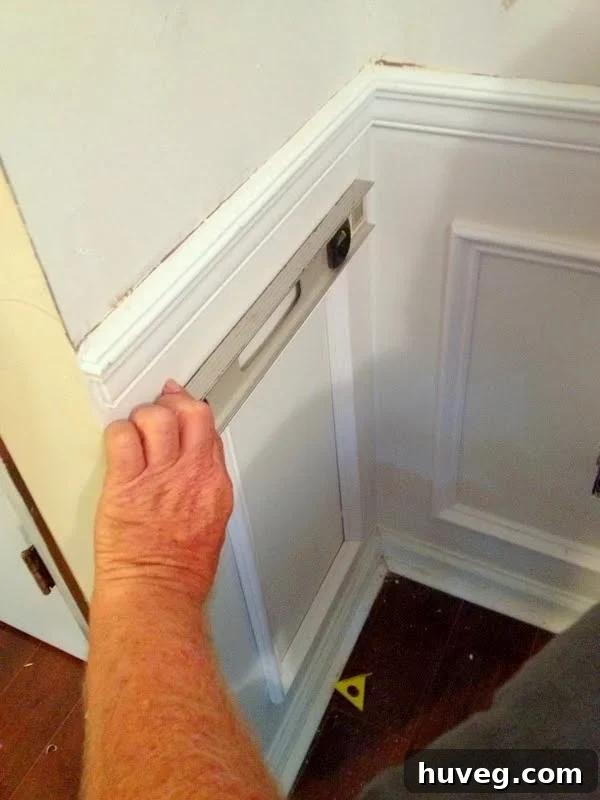 Using a level to ensure proper alignment of installed molding box