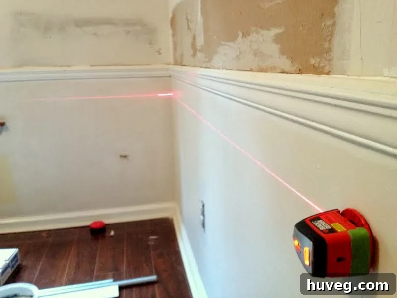 Using a paint stick spacer and laser level for marking moulding placement