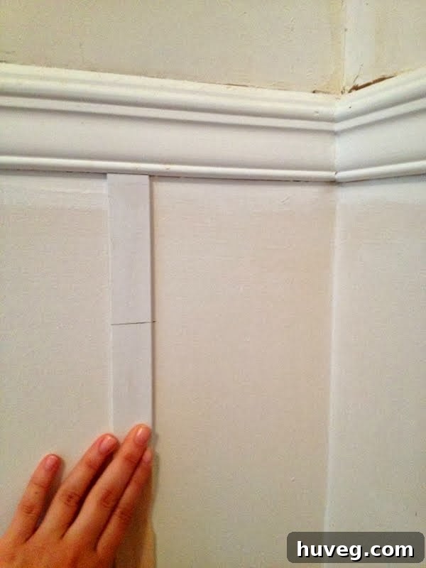 Close-up view of picture frame molding expertly installed around a wall outlet, demonstrating custom fitting