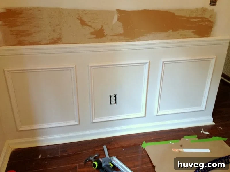 Picture frame molding on a wall featuring an electrical outlet, showcasing design adaptation