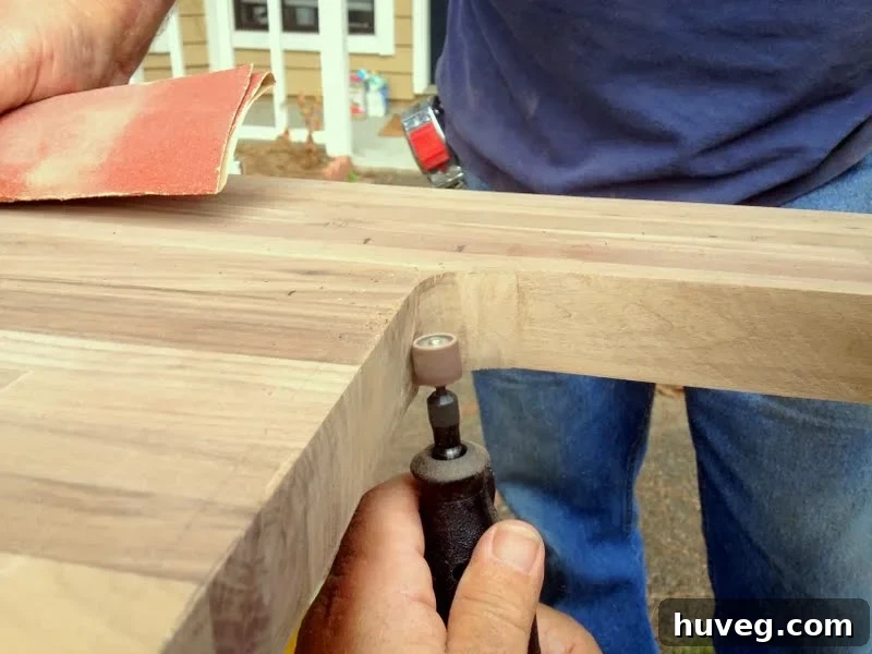 Sanding the repaired sink hole in butcher block