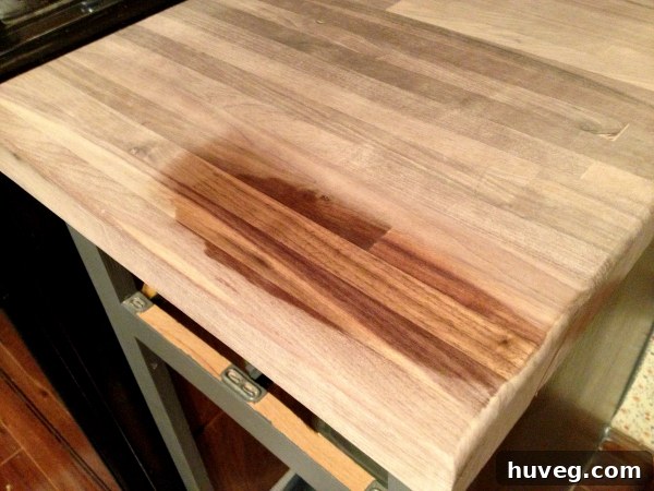 Close-up of walnut butcher block countertop being treated with mineral oil and beeswax