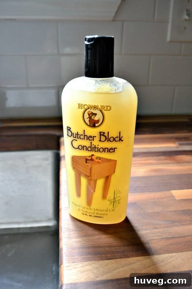 Howard Butcher Block Wood Conditioner, a blend of mineral oil and beeswax, on a countertop.