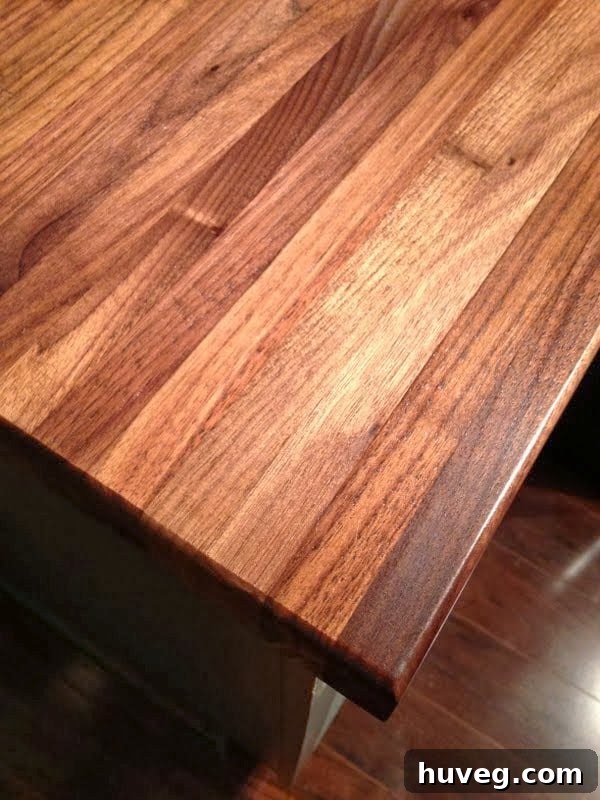 Detailed close-up of the wood grain and rich color on a treated walnut butcher block countertop.
