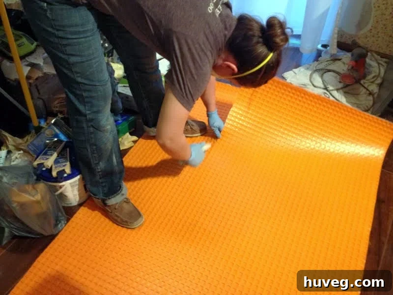 Smoothing Ditra with a grout float for tile over concrete subfloor