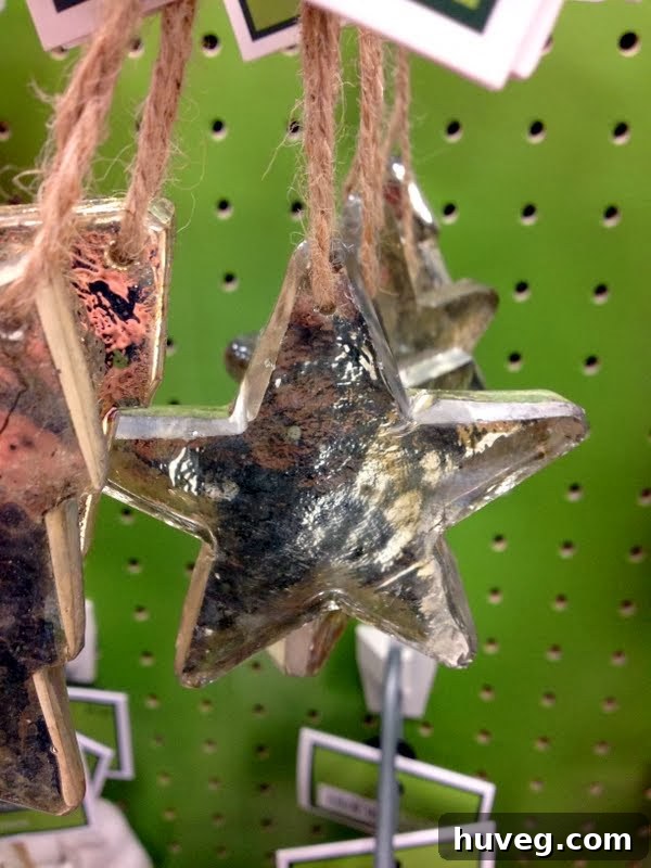 A close-up of a Christmas ornament in the unique silver-gold blend, possibly a star or abstract shape, glistening under the light.