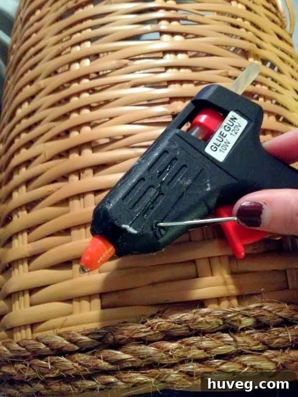Applying E-6000 adhesive to secure the first layer of manila rope to the basket base.