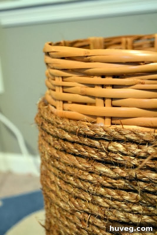 Wrapping a basket with manila rope using a hot glue gun for quick adhesion.