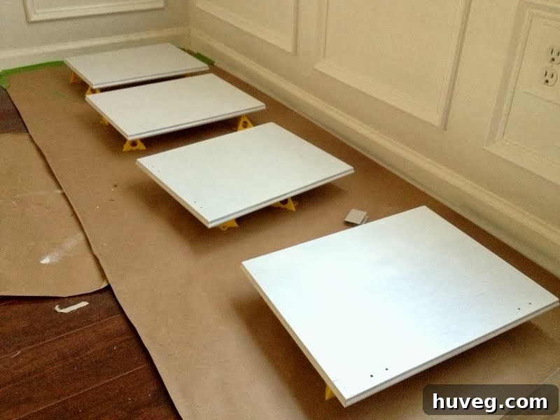 Close-up of cabinet doors drying on paint pyramids, showing the smooth, clean white finish and the efficient use of space.