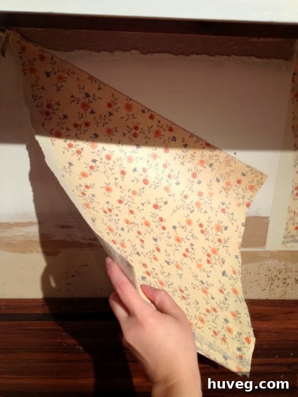 Close-up of old, peeling kitchen wallpaper showing grime