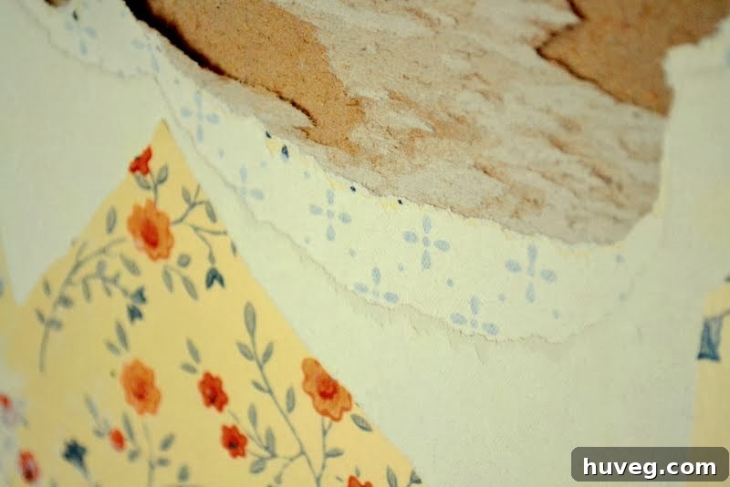 Damaged wall after removing two layers of stubborn wallpaper during renovation