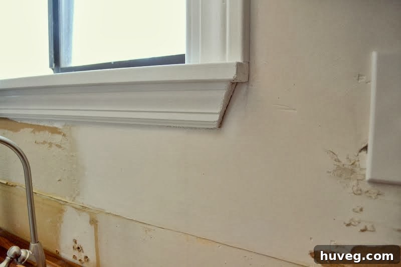 Damaged kitchen walls after wallpaper removal, showing areas needing repair