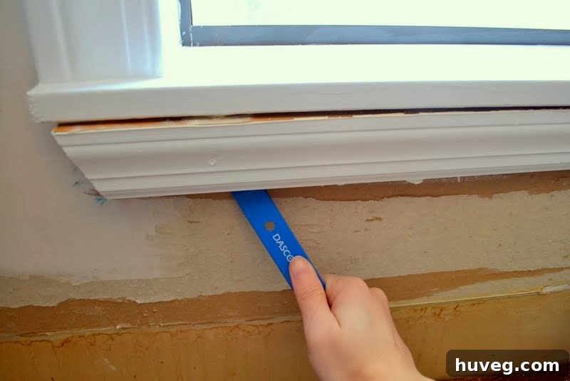 Prying off existing window trim before tiling the kitchen backsplash