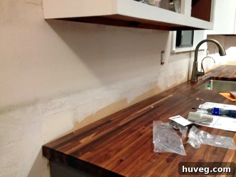 Rough patching of drywall with joint compound for kitchen backsplash prep