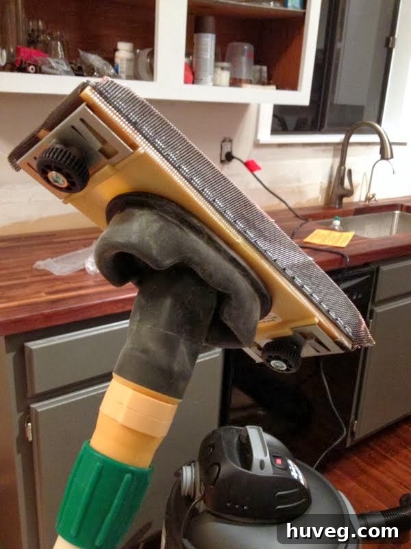 Drywall sanding attachment connected to a shop vacuum for dust-free sanding
