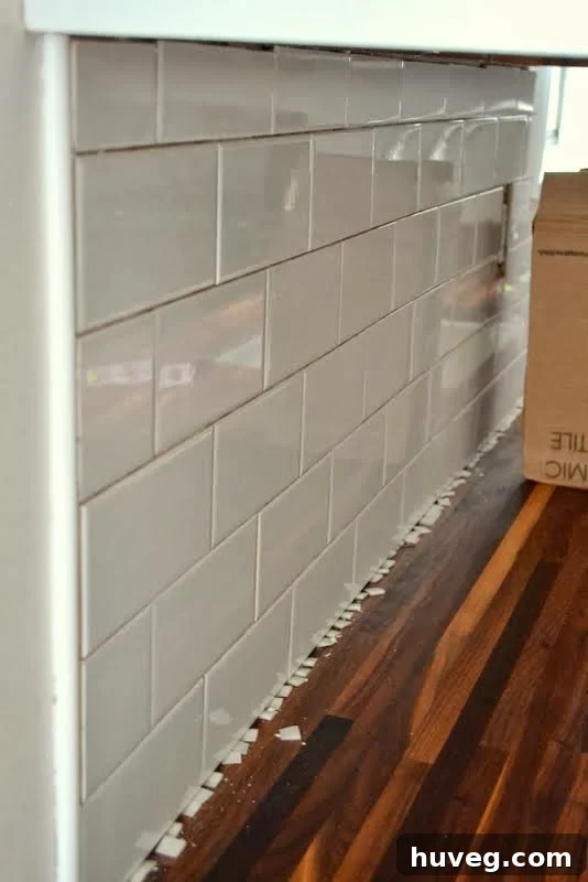 Completed section of a DIY kitchen backsplash before grouting