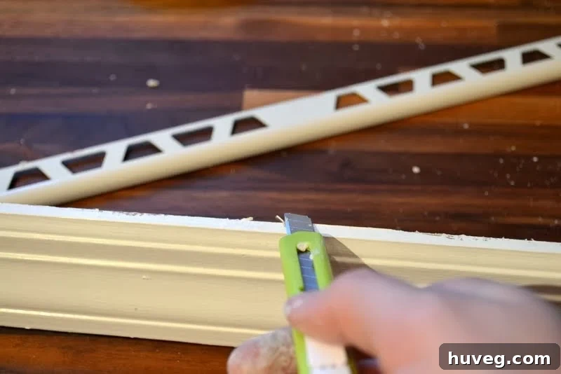 Trimming off old caulk from window trim for a clean, tight fit during reinstallation
