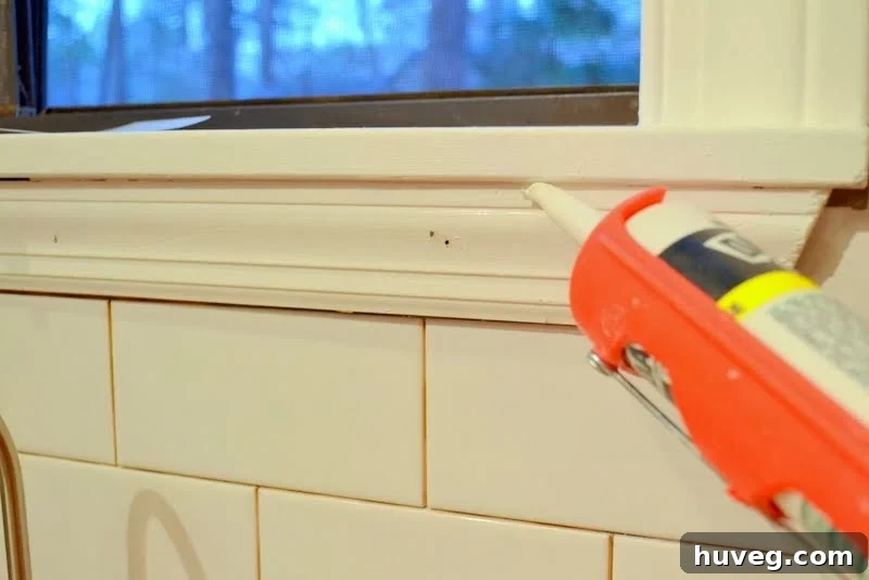 Caulking and filling holes in newly installed window trim for a flawless backsplash finish