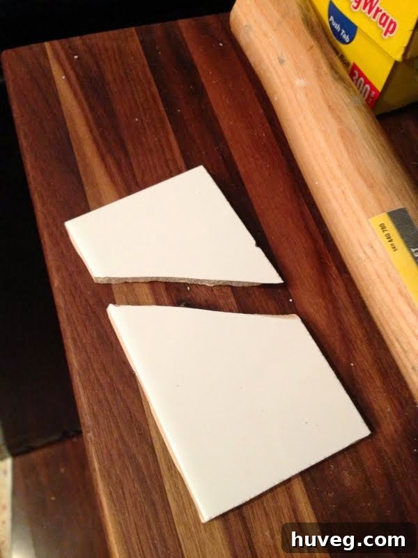 A broken piece of ceramic tile after a DIY mishap during kitchen renovation.
