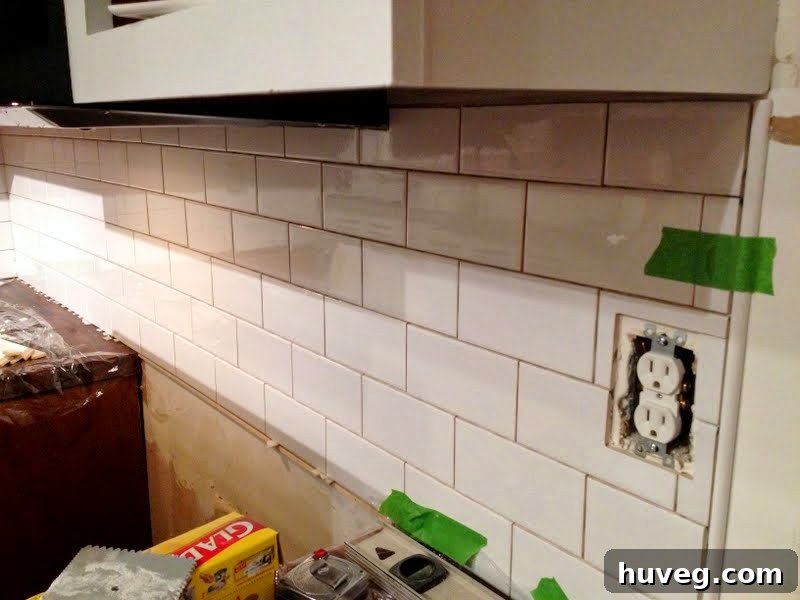 A view of a kitchen renovation in progress, showing tools and tiling work.