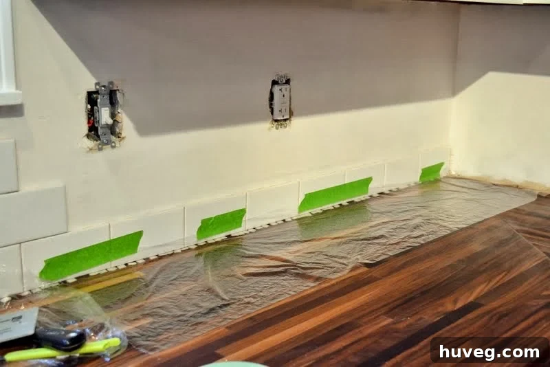 Using Frog Tape to hold first row of subway tile to wall