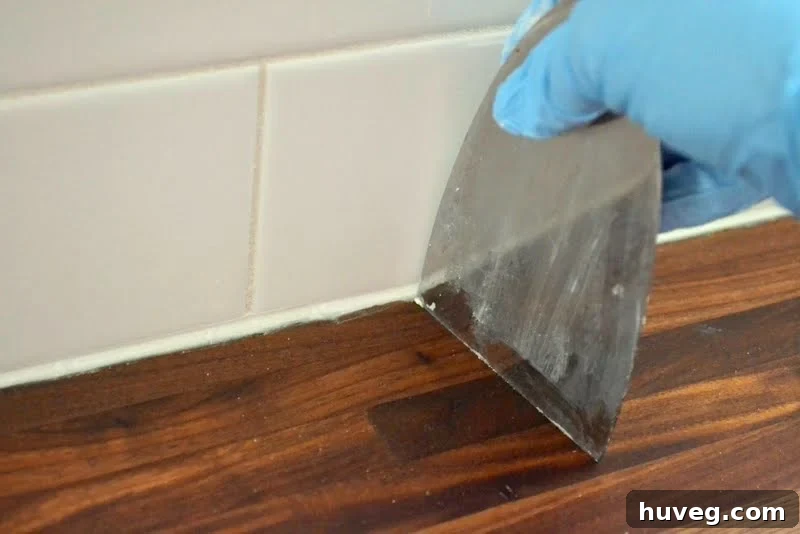 Use a putty knife to clean excess caulk