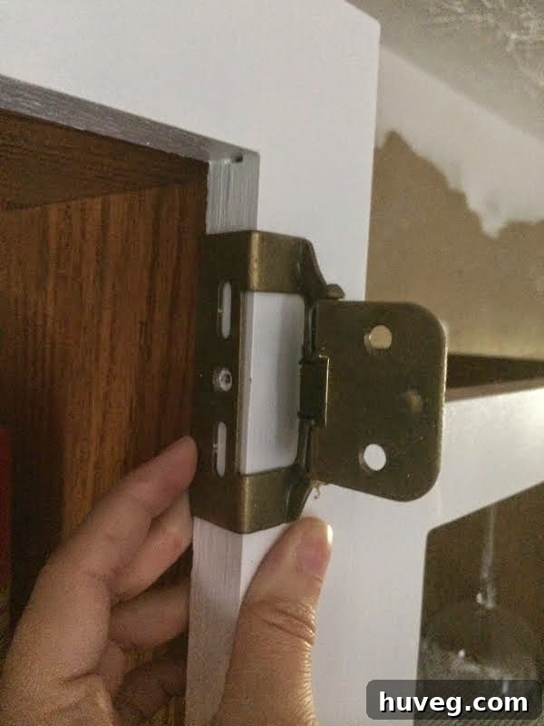 Close-up of cabinet hinge installation process