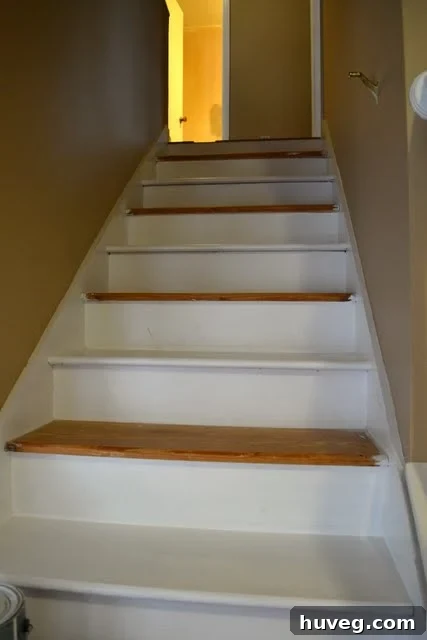Close-up of the stubborn stair handrail bracket with stripped screws, illustrating the initial challenge