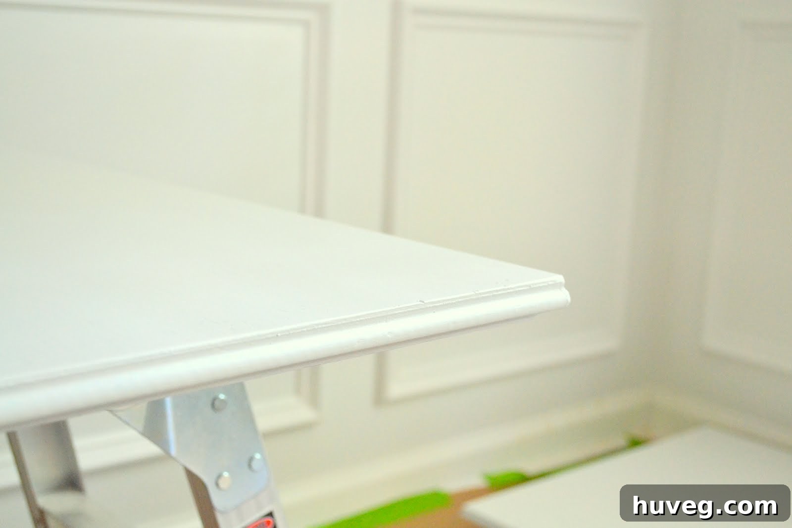 Freshly painted kitchen cabinet doors curing on a workspace, signaling the near completion of a DIY kitchen renovation