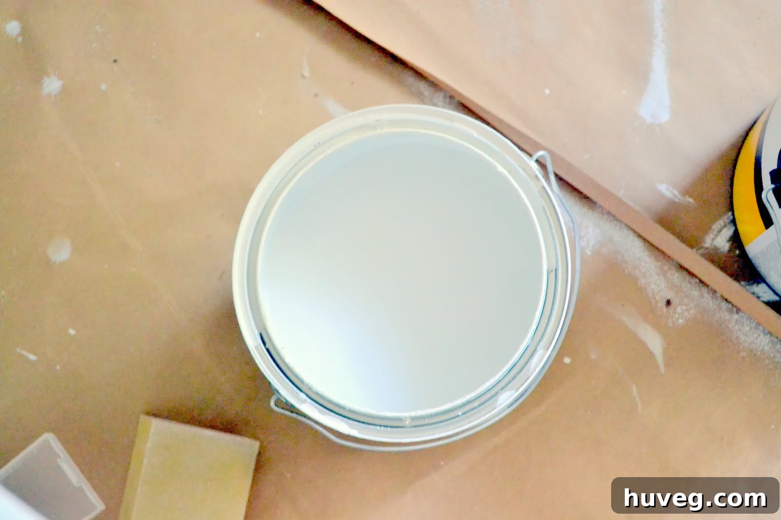 Paint cans and rollers, tools of the DIY kitchen renovation trade, scattered during a home improvement project