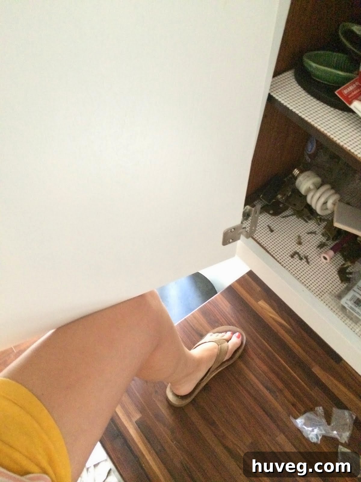 DIY enthusiast performing lunges to support a cabinet door during installation.