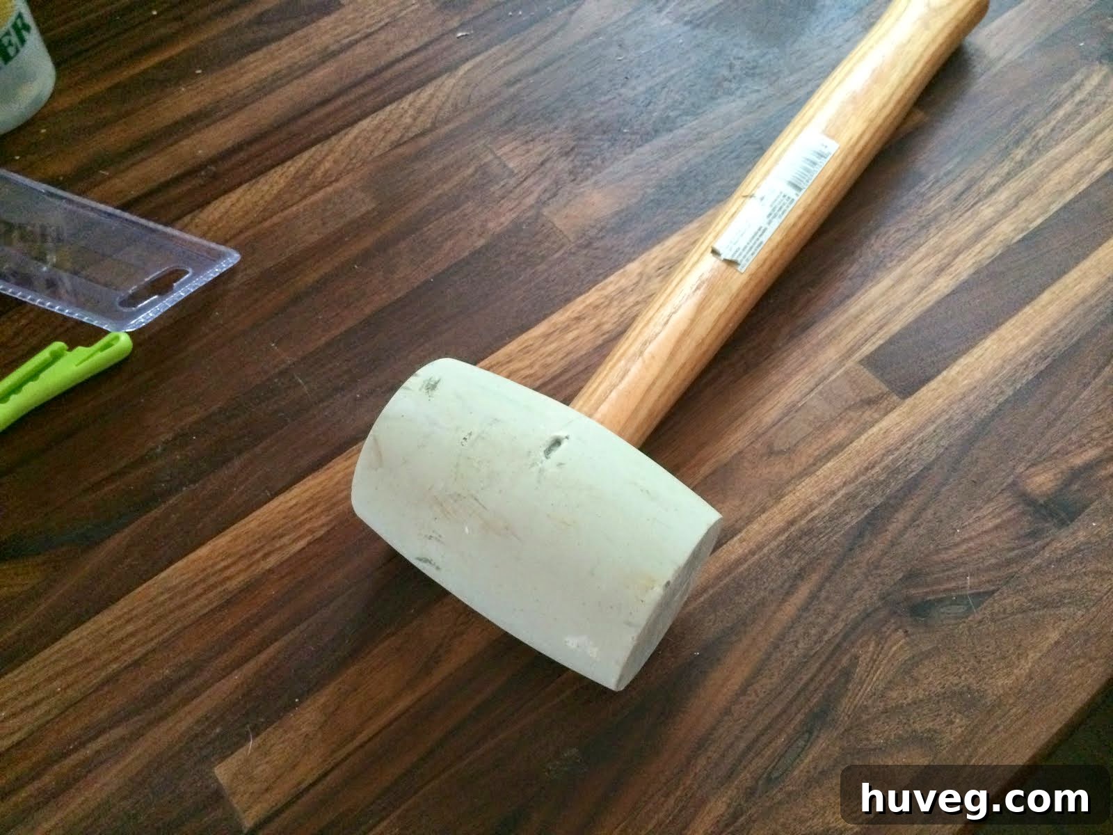 A rubber mallet being used to adjust a kitchen cabinet component.