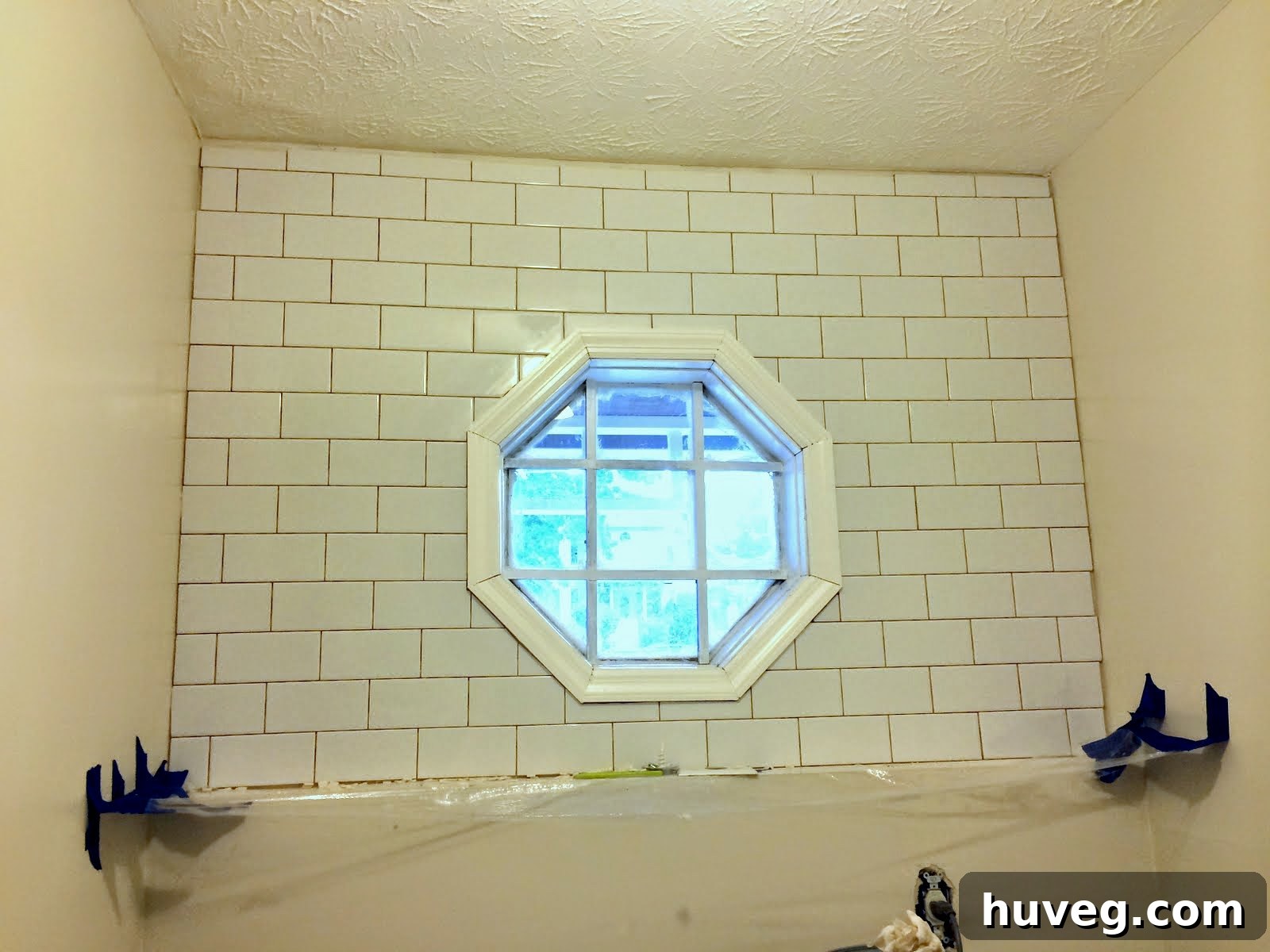 Beautifully grouted tile backsplash nearing completion in a modern laundry room, showcasing a clean finish